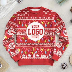 Könnte beinhalten: Roter Weihnachtspullover mit festlichem Muster. Das Design umfasst weiße Schneeflocken, Rentiere, Häuser und Lichterketten. Ein großer weißer Kreis in der Mitte lautet "YOUR LOGO HERE". Zusätzlicher Text "YOUR LOGO HERE" befindet sich auf den Ärmeln.