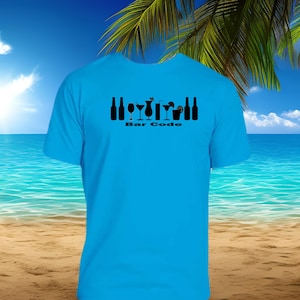 May include: A turquoise blue t-shirt with a black graphic of bar-related icons, including bottles and cocktail glasses. The text "Bar Code" is printed below the graphic. The background features a beach scene with palm trees, sand, ocean, and a blue sky.