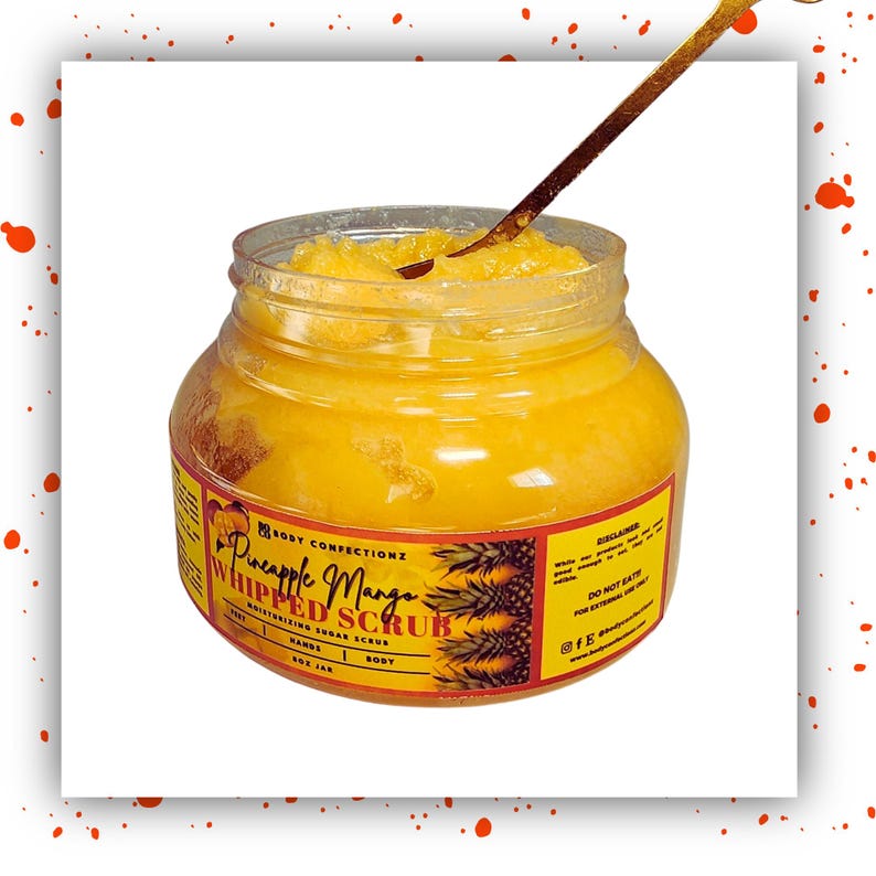 May include: A glass jar filled with a yellow whipped sugar scrub. The label reads "Pineapple Mango Whipped Scrub" with a pineapple graphic. The jar is on a white background.