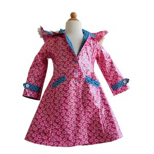 Puede incluir: Una gabardina rosa con ribetes azules y un estampado floral. La gabardina tiene capucha y mangas largas.