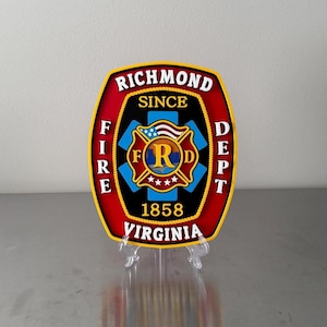 May include: A decorative badge featuring the words "RICHMOND FIRE DEPT" in white lettering on a red and black background. The badge includes a central emblem with the letters "FRD" and the text "VIRGINIA 1858".