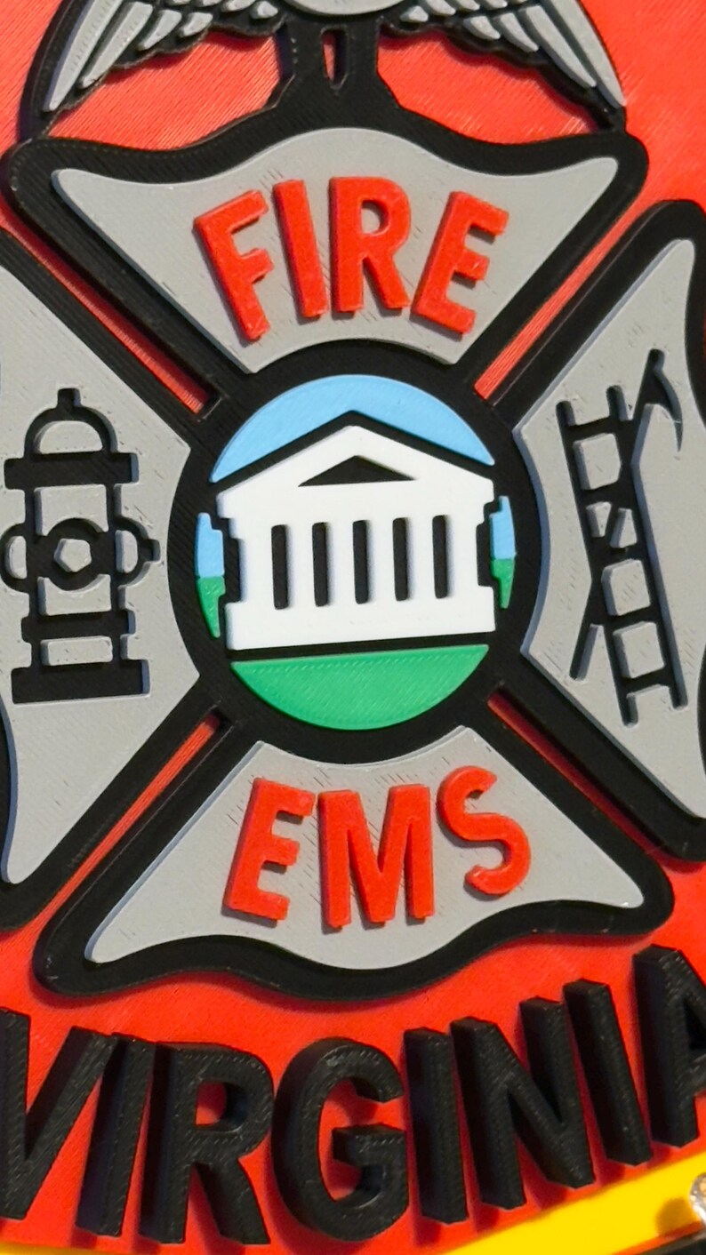 May include: A red and black fire department emblem with the words "FIRE EMS" and "VIRGINIA" in black lettering. The emblem features a white building with columns, a fire hydrant, and a ladder.