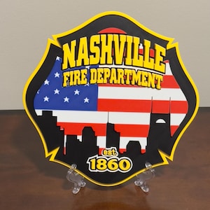 May include: A black and yellow fire department shield with a red, white, and blue American flag, a silhouette of a city skyline, and the text "Nashville Fire Department est. 1860".