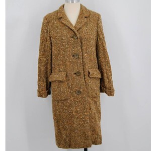May include: A vintage brown tweed coat with a notched collar, three buttons, and two front pockets. The coat is displayed on a mannequin against a white background. The tweed fabric has flecks of orange and white.