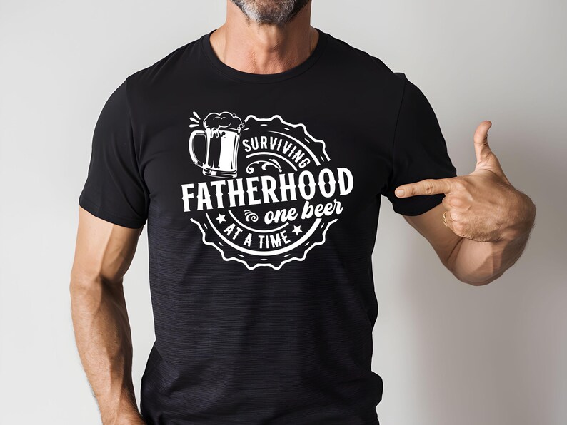 May include: Black t-shirt with a white graphic design of a beer mug and the text "Surviving Fatherhood one beer at a time".