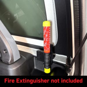 May include: A black plastic fire extinguisher mount secured to a vehicle interior panel. The mount holds a cylindrical fire extinguisher with a red label featuring white numbered instructions and a bright yellow cap and base.