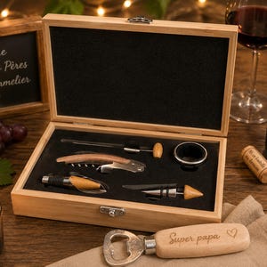 Op de afbeelding: Een houten wijnopener set in een doos, met een kurkentrekker, flesstopper en andere gereedschappen. De doos is open en toont de gereedschappen op een zwarte fluwelen voering. Een fles wijn en een glas staan op de achtergrond. De tekst "Super papa" staat gegraveerd op een houten flesopener.