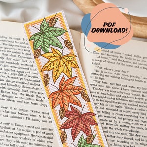 May include: A handmade bookmark with a design of autumn leaves in green, yellow, orange, and red. The bookmark is rectangular with a white background and a yellow border. The text "PDF DOWNLOAD!" is in a speech bubble.