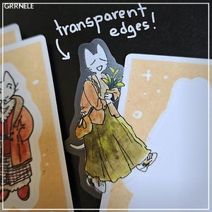 May include: A clear sticker with a cartoon illustration of a cat wearing a brown jacket and holding a potted plant. The sticker has transparent edges and the text "transparent edges!" is written above the cat.