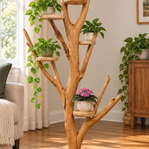 May include: A tall, light brown wooden plant stand shaped like a tree with a thick circular base and multiple branches. Five flat, round platforms are attached to the branches, each holding a potted plant with green foliage or pink flowers.