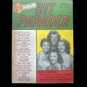 May include: A vintage magazine cover for Hit Parader, a music magazine, featuring a group of four women singers. The cover is yellow and green with the title "Hit Parader" in red and black letters. The magazine cover lists popular songs of the time, including "Let Me Go Lover", "The Naughty Lady of Shady Lane", "Mister Sandman", and "Dim Dim the Lights".