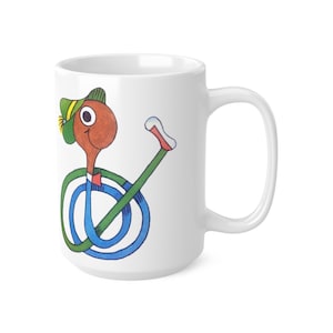 May include: White ceramic mug with a cartoon character illustration. The character has a brown head, green hat, and a green and blue body. It holds a green stick with a red and white tip. The mug has a large handle.