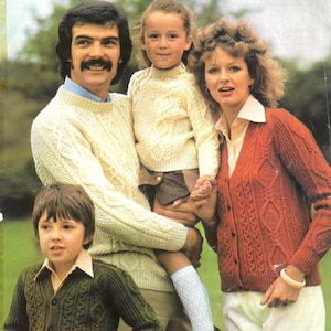 Könnte beinhalten: Titelbild eines Strickmusterbuchs namens "Aran Style Knitting" von Richard Poppleton. Die Abbildung zeigt eine Familie in Aran-Strickwaren: cremefarbene Pullover, eine grüne Strickjacke und eine rote Strickjacke. Die Familie steht im Freien.