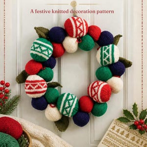 May include: A circular wreath made of knitted spheres in red, green, white, and navy blue. Some spheres feature white geometric patterns. The wreath includes knitted green leaves and is displayed against a white door with the text A festive knitted decoration pattern.
