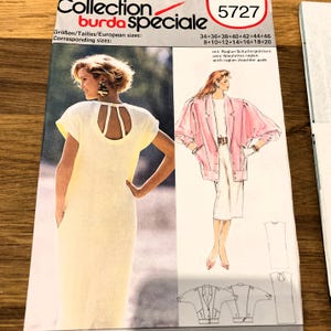 May include: A Burda Speciale sewing pattern envelope 5727 featuring a light yellow dress with a cutout back and a pink blazer with raglan shoulder pads. The cover displays illustrations and photographs of the garments with European sizes 34-46.
