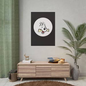 Puede incluir: Un estampado enmarcado con un perro de dibujos animados con un hueso en la boca, sobre un fondo negro dentro de un c&iacute;rculo blanco. La obra de arte se exhibe en una pared sobre un mueble de madera.