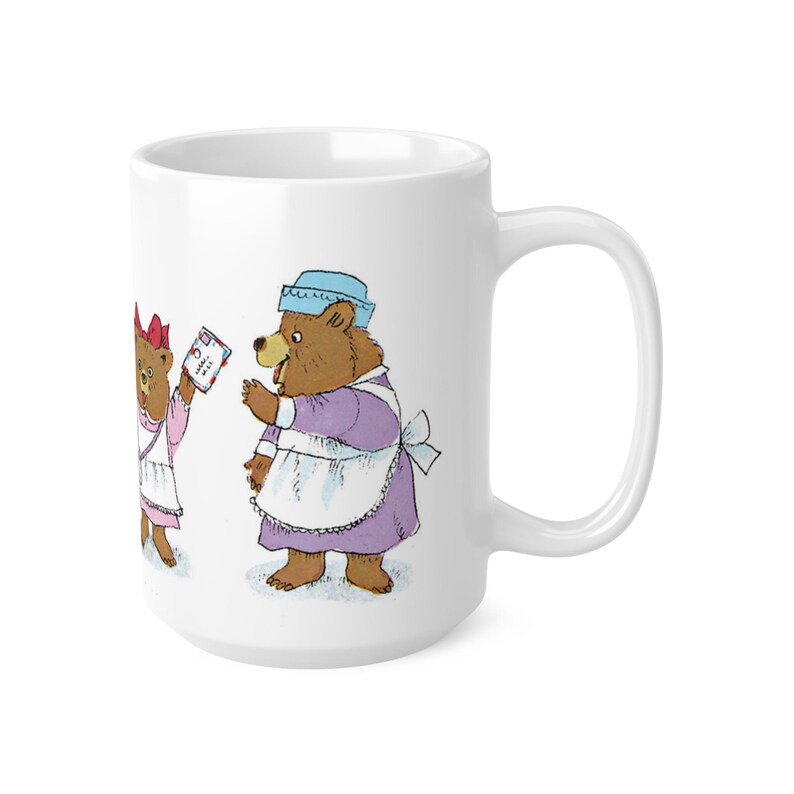 May include: White ceramic mug with a colorful illustration of three bears wearing dresses and aprons. The bears are holding letters and packages.