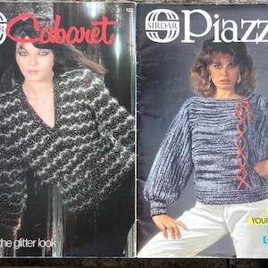 May include: Two vintage knitting pattern booklets. The left booklet features a black and silver glittery V-neck sweater with the text Cabaret. The right booklet displays a blue and white textured sweater with a red lace-up detail and the text Sirdar Piazza.