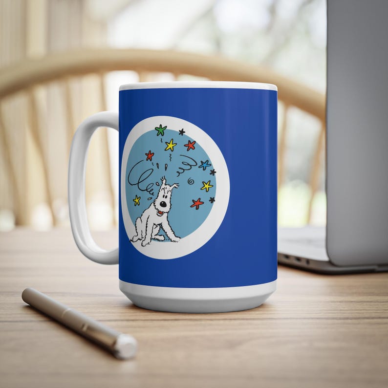 May include: A white ceramic mug with a blue background and a cartoon illustration of a white dog with a swirl and star design. The mug has a white handle and base, and is sitting on a wooden surface.