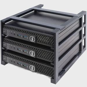 May include: A black server rack containing three black Dell computers. The computers are stacked vertically within the rack, with the Dell logo visible on each. The rack has a sturdy, industrial design.