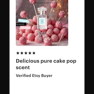 May include: A perfume bottle with a light blue label is surrounded by pink cake pops on sticks and pink frosted cake pops. The text on the bottle reads "ESTLETIQUE EXTRAIT DE PARFUM". The text "CAKE POPS 30 ml" is also visible.