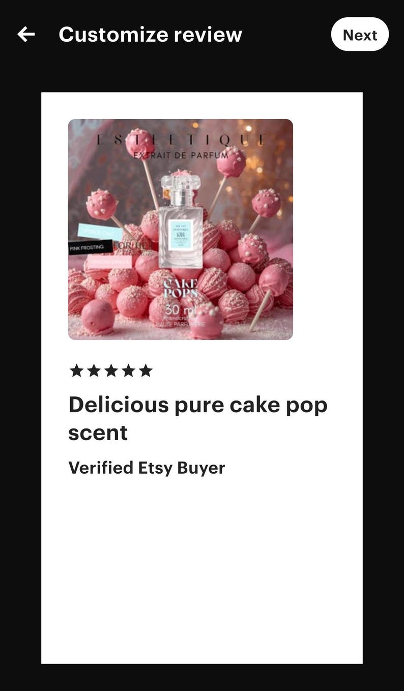 May include: A perfume bottle with a light blue label is surrounded by pink cake pops on sticks and pink frosted cake pops. The text on the bottle reads "ESTLETIQUE EXTRAIT DE PARFUM". The text "CAKE POPS 30 ml" is also visible.