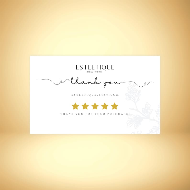 May include: A white thank you card with the text "ESTEETIQUE NEW YORK" at the top. The words "thank you" are written in cursive. Below are five gold stars and the text "THANK YOU FOR YOUR PURCHASE!"