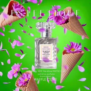 Puede incluir: Un frasco de perfume transparente de diseño rectangular con una tapa de cristal. La etiqueta dice "WAFFLE CONE" con la marca "ESTETIQUE NEWYORK". La imagen presenta conos de waffle con flores y pétalos rosas sobre un fondo verde.
