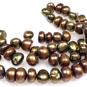 May include: A strand of brown and green baroque freshwater pearls. The pearls are irregular in shape and have a high luster.