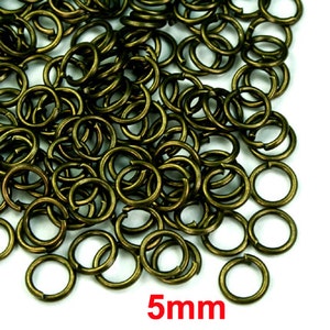 Puede incluir: Un mont&oacute;n de anillas de salto doradas de 5 mm. Estas anillas son perfectas para la elaboraci&oacute;n de joyas, la artesan&iacute;a y otros proyectos de bricolaje.