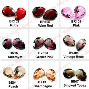 May include: Assortment of pear-shaped gemstones in various colors, including ruby, amethyst, wine red, garnet pink, vintage rose, peach, champagne, and smoked topaz. Each gemstone is labeled with its name and code.