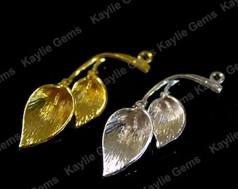 May include: Two leaf-shaped metal charms, one gold and one silver, with a textured surface. Both charms have a loop at the top for attaching to jewelry or other crafts.