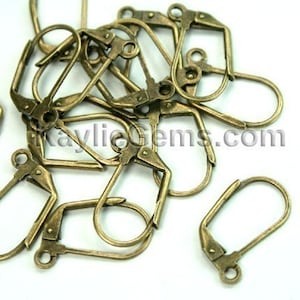 May include: A pile of antique brass earring hooks. The hooks are made of metal and have a simple, classic design.