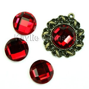 May include: Three red glass round rhinestones with a faceted design and a bronze metal pendant with a red glass round rhinestone with a faceted design.