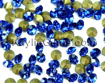 May include: A scattering of blue rhinestones with gold settings. The rhinestones are round and have a faceted design.