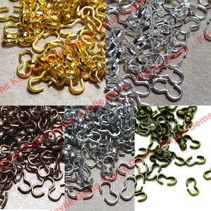 May include: Assortment of four colors of metal jump rings. The jump rings are in gold, silver, bronze, and antique silver. The jump rings are all the same size and shape.