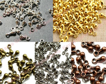 May include: Assortment of small, teardrop-shaped metal beads with a loop at the top. The beads are shown in four different colors: silver, gold, bronze, and copper.
