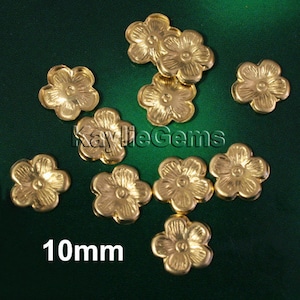 May include: Ten gold-colored metal flower embellishments, each measuring 10mm in diameter. The flowers have five petals and a raised center.