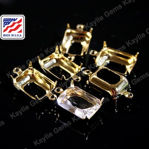 Puede incluir: Ajustes de metal dorado para piedras preciosas de forma rectangular. Los ajustes tienen garras en la parte superior e inferior y dos bucles en los lados. Hecho en los EE. UU.