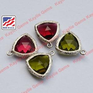 May include: Four triangle-shaped glass charms with silver-toned metal settings. Two charms are red and two are green.