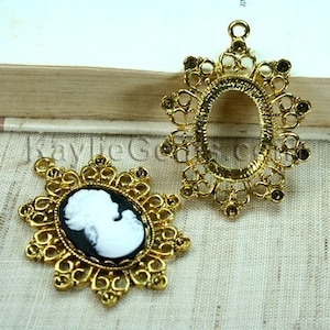 Peut inclure: Deux cadres de camée en métal doré. Un cadre est vide et l'autre contient un camée blanc représentant le profil d'une femme.