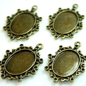Könnte beinhalten: Vier antike goldfarbene Metall-Anhänger-Tabletts mit einer ovalen Öffnung. Die Tabletts haben ein dekoratives, verziertes Design mit einem gewellten Rand.