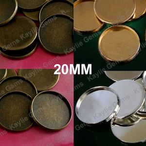 May include: Assortment of 20mm round metal tray bases in antique brass, gold, and silver finishes. The bases are ideal for crafting jewelry, resin art, and other projects.