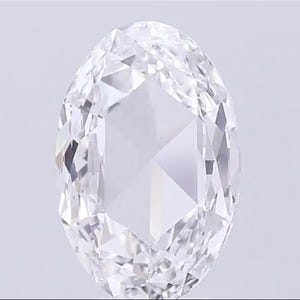 Puede incluir: Una gema clara, de talla ovalada, con numerosas facetas, que refleja la luz. El interior de la gema presenta un complejo patrón de formas triangulares y de diamante, creando un brillo brillante. La piedra se encuentra sobre un fondo liso y claro.