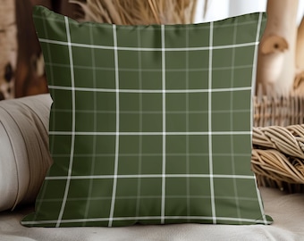 May include: A square decorative pillow with a green plaid pattern. The pillow features a grid of white lines over a solid green background. The pillow is a home decor item.