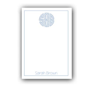 May include: A white notepad with a pale blue border and a matching monogram. The monogram, featuring the letters "SBD", is in a circular design at the top. The name "Sarah Brown" is printed in pale blue at the bottom.