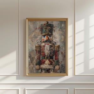 Puede incluir: Una impresión enmarcada de un colorido soldado cascanueces. La obra de arte presenta una representación detallada del cascanueces en un marco dorado, con un fondo texturizado. El cascanueces viste un uniforme rojo, verde y dorado.