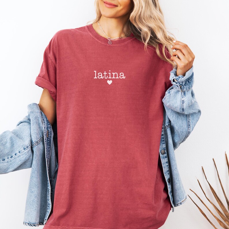 May include: A red t-shirt with the word "latina" and a small heart printed on the front.
