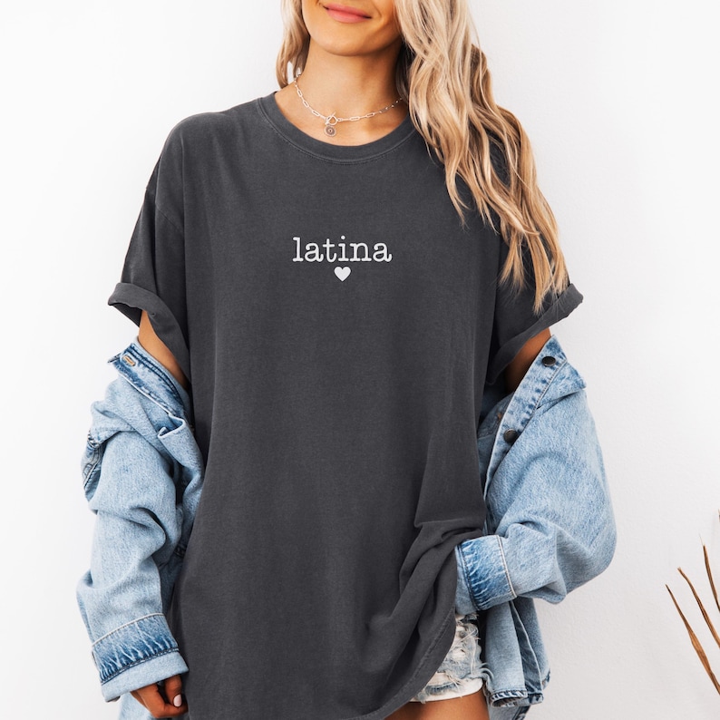 May include: A dark gray oversized t-shirt with the word "latina" and a small white heart printed on the front.