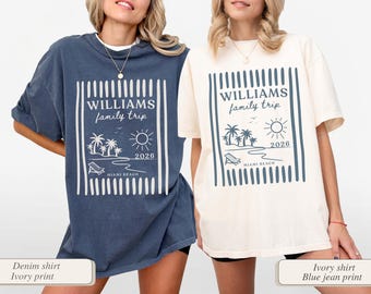May include: Two oversized t-shirts, one denim blue and one ivory, each featuring a graphic with the text "WILLIAMS family trip 2026 MIAMI BEACH." The design includes palm trees, a sun, and a beach chair.